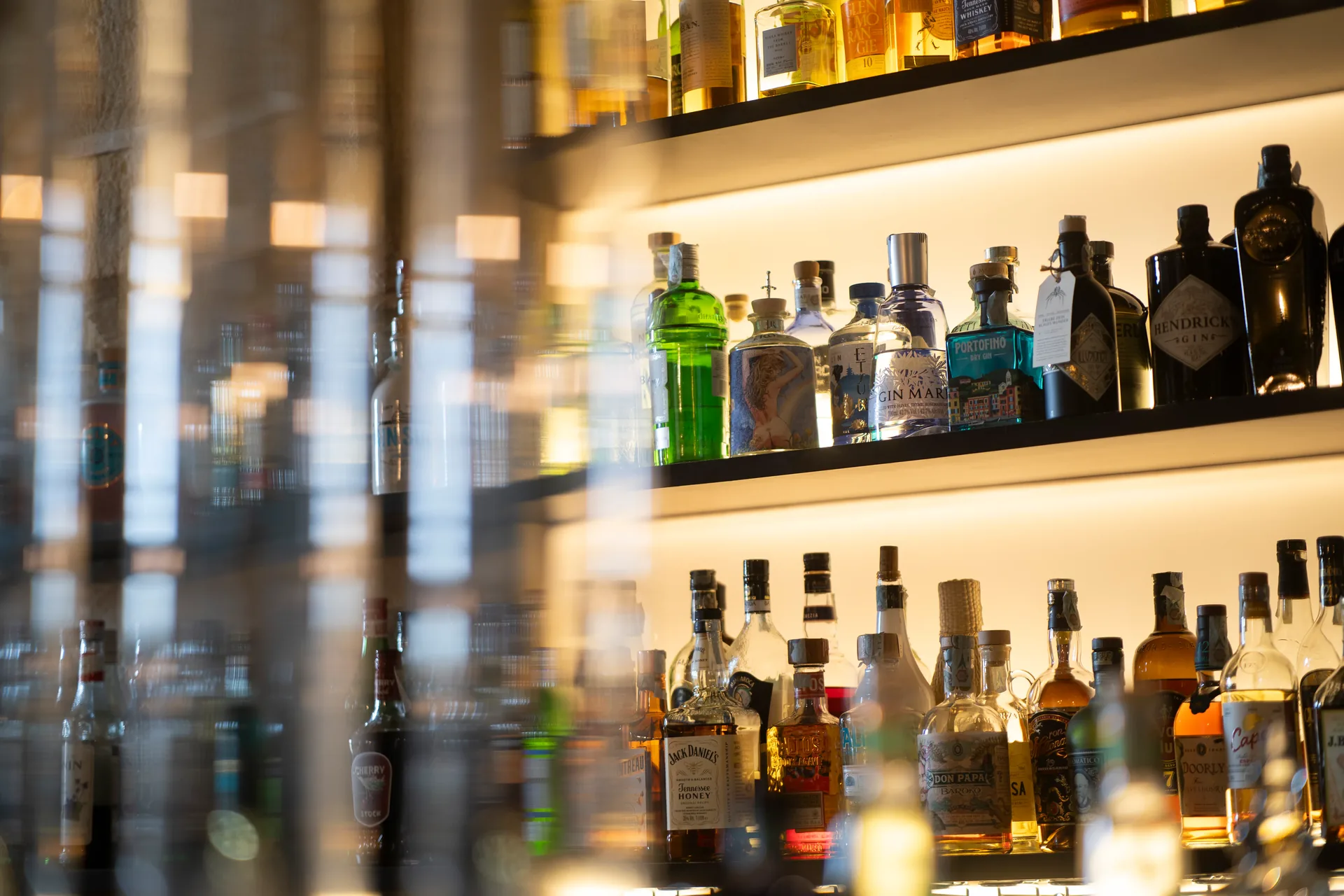 Selezione di gin e distillati retroilluminati al bancone